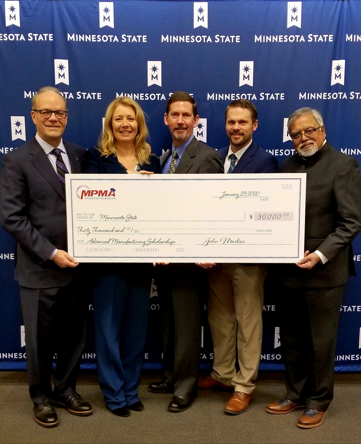 Five people holding very large check