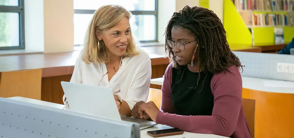 Staff and student working on computer